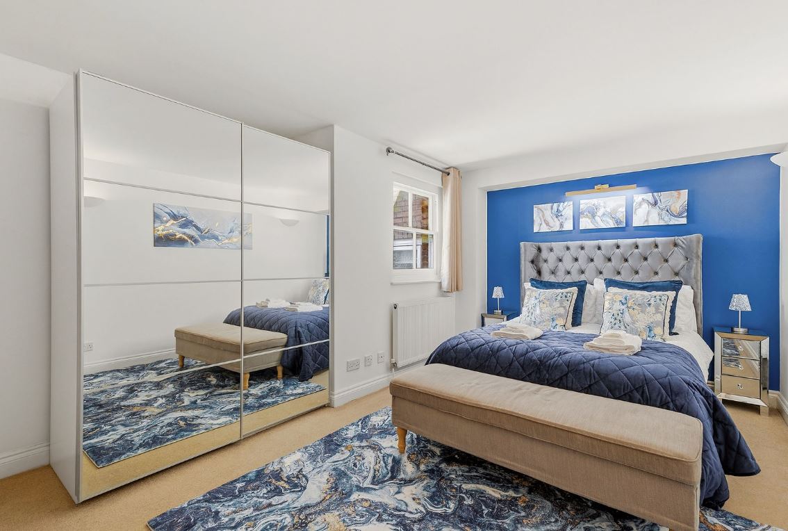 Luxury bedroom with mirrored wardrobe and dressed bed