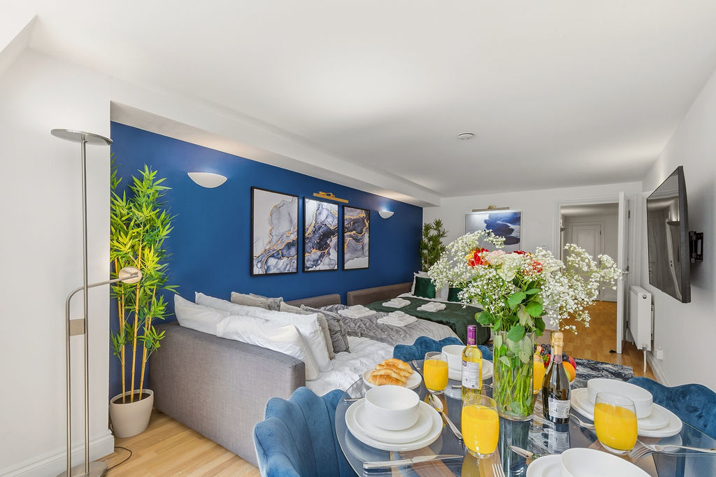 Open-plan room with dining setting and feature wall